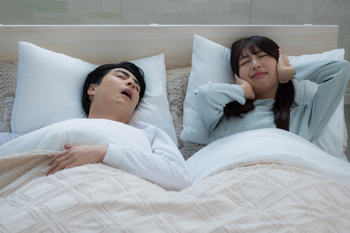 ベッドでいびきをかきながら眠る若い男性│いびきって病気？