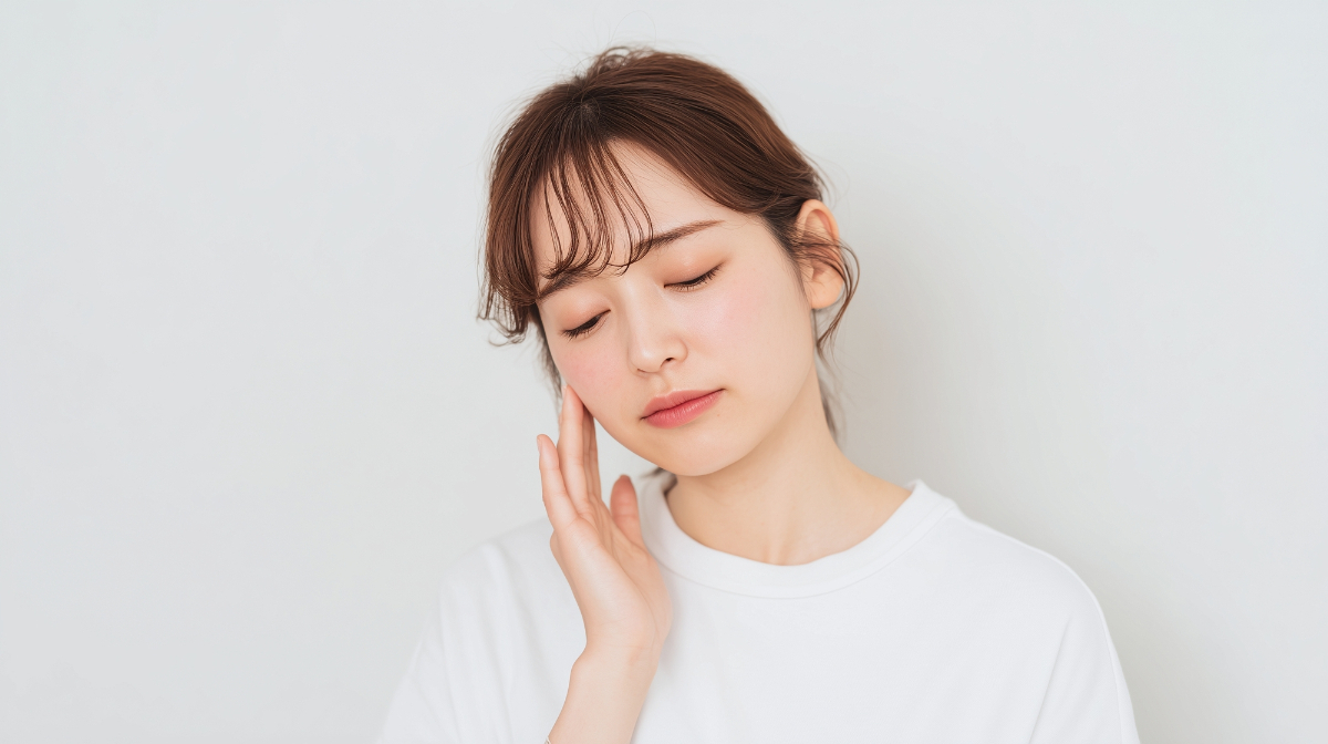 顔から首にかけて違和感を感じる女性のイメージ│顔・首まわりの疾患と症状